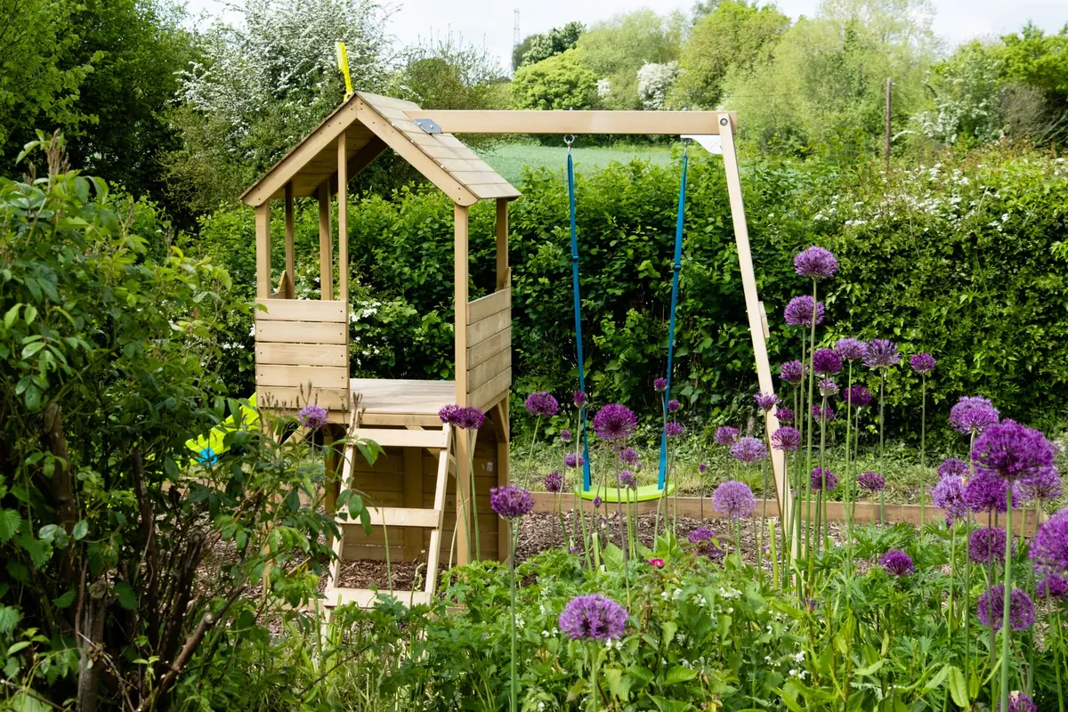 The wooden climbing frame and swing in the garden