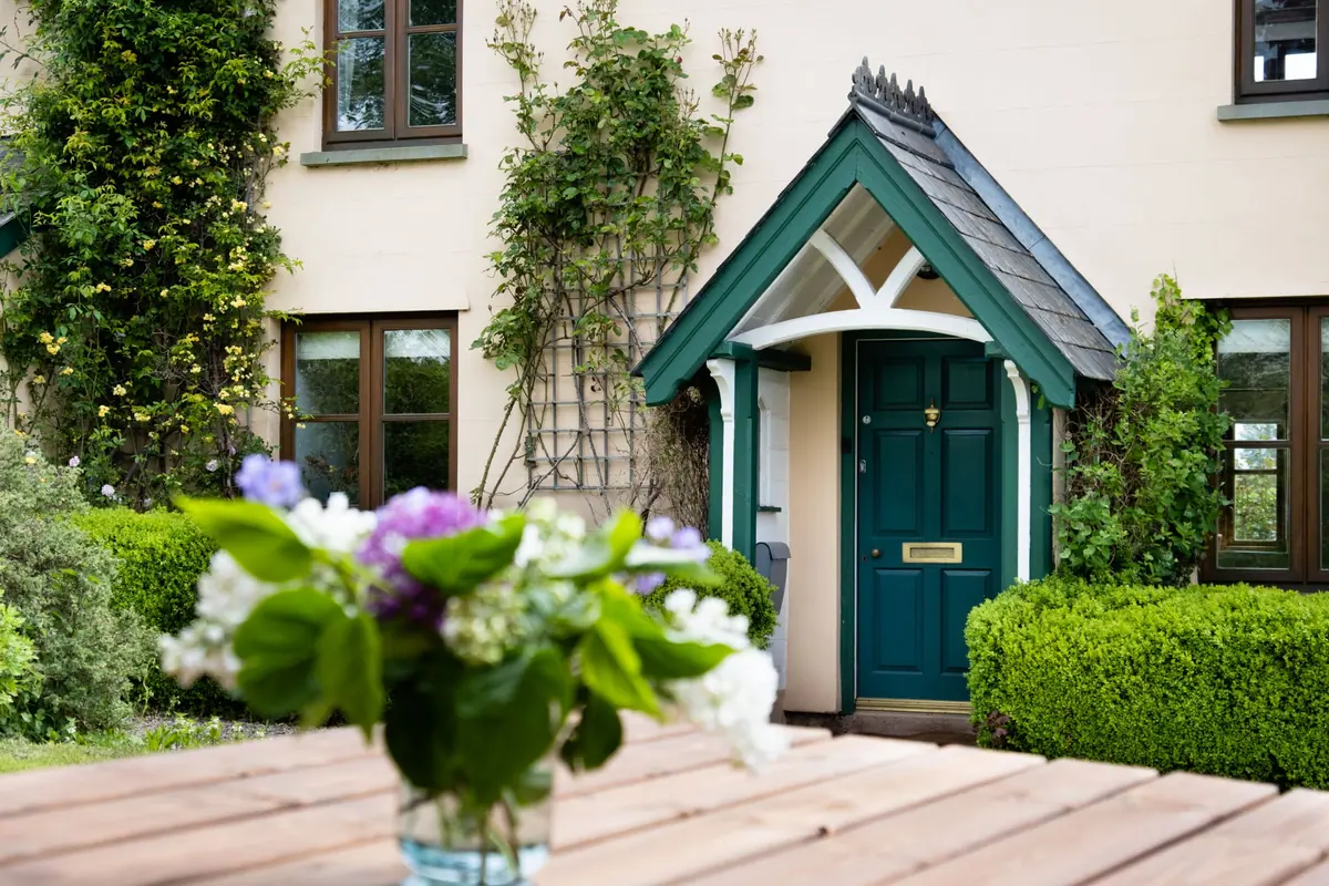 The green front door and porch of the main house