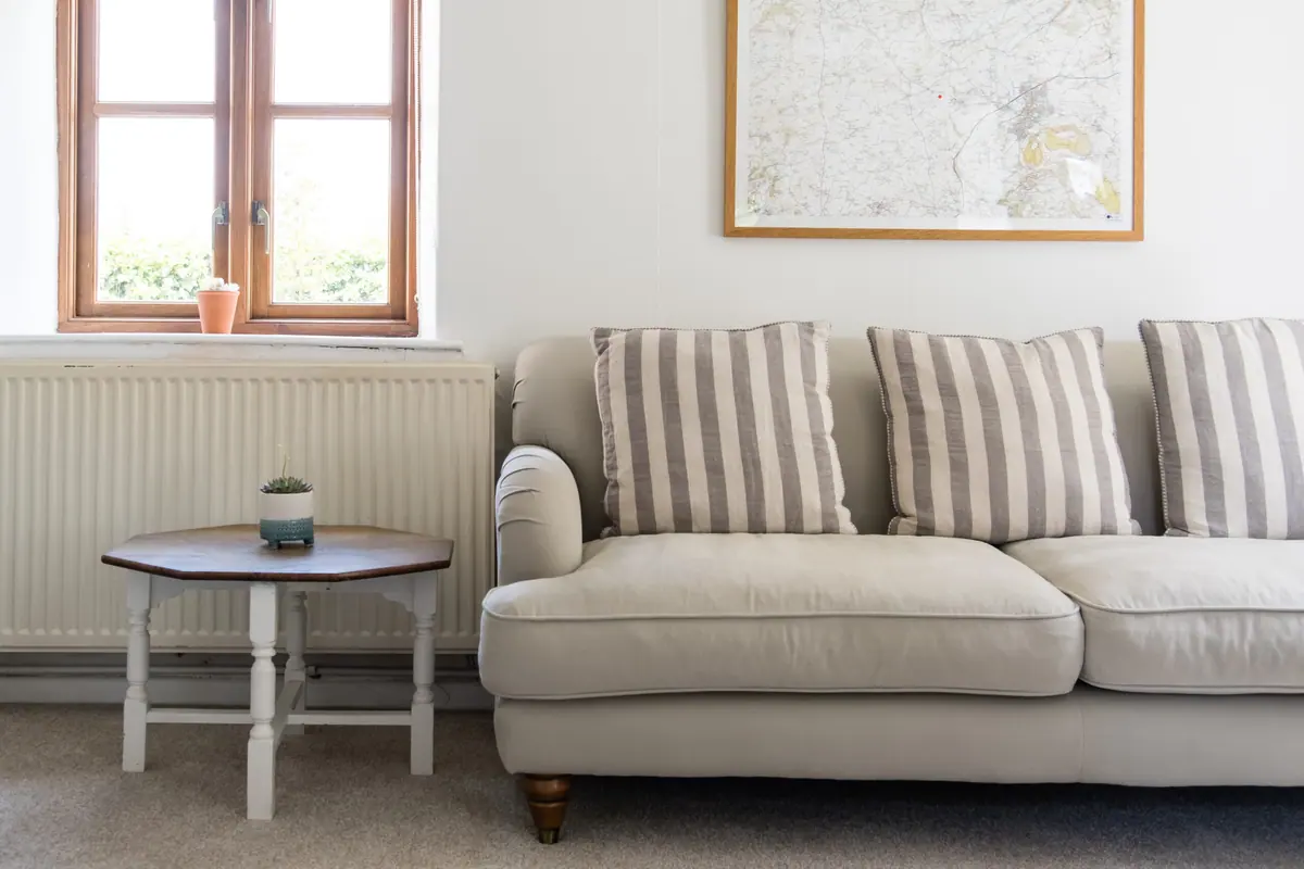 A striped sofa beneath a framed map