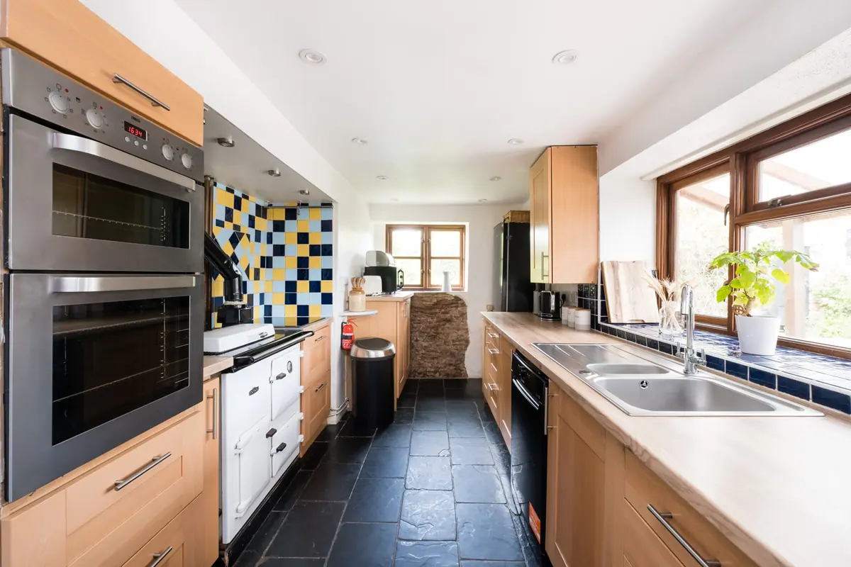 The kitchen with slate floor and wooden units