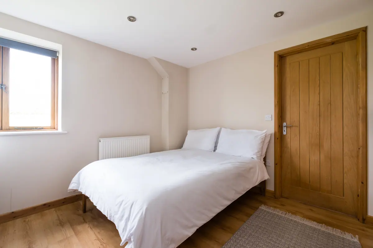 A bedroom in the annexe with a wooden door